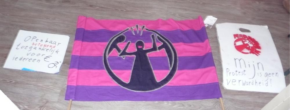 Roze-paars gestreepte vlag met daarop het logo van Mad Pride.